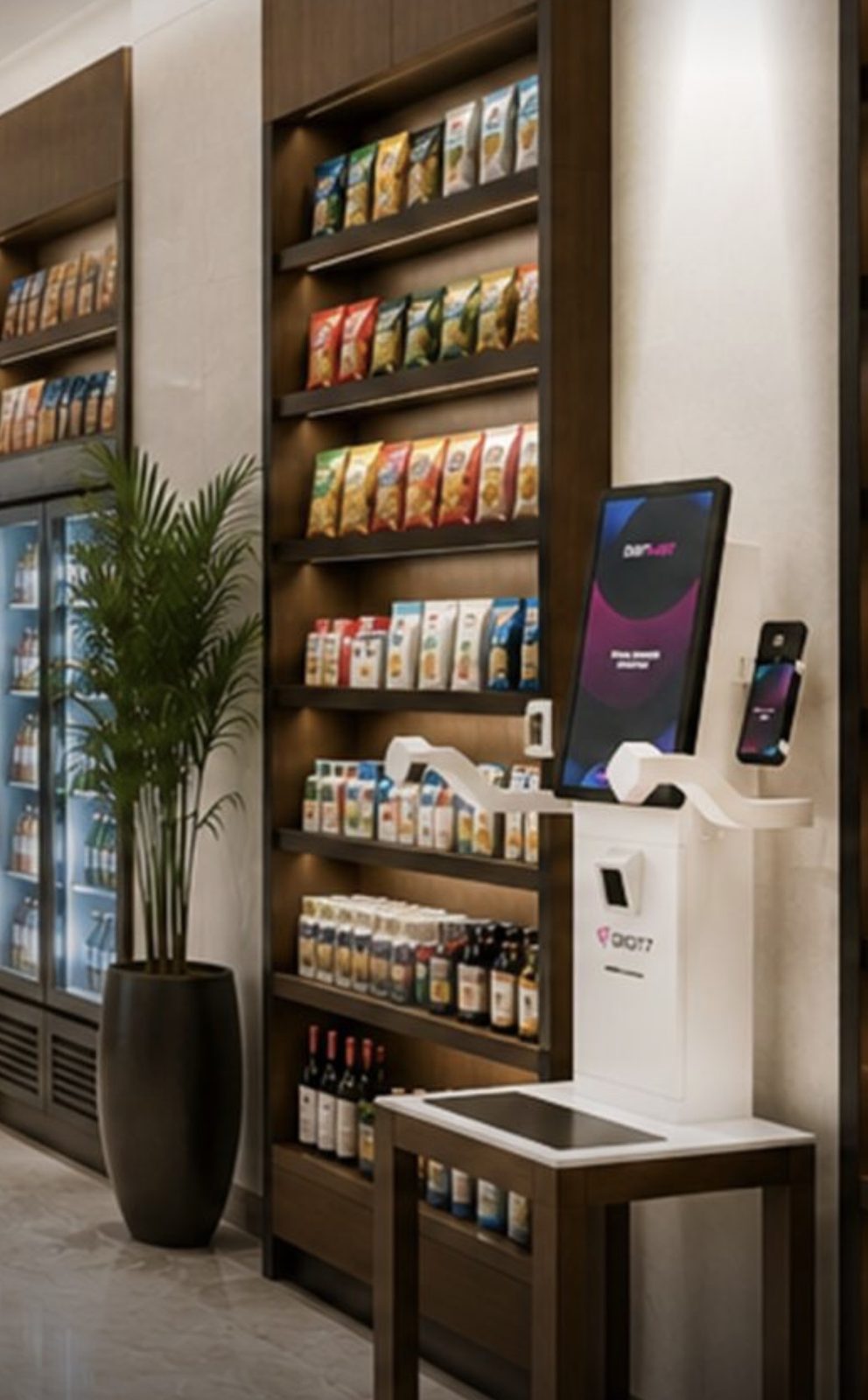 A hotel retail wall installation with lit shelving, smart coolers, and a vision checkout station